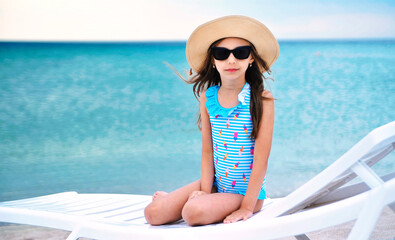 Wall Mural - Cute little girl has fun on the beach. 