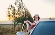 © Rung Kh - Young woman standing enjoy life on the car of travel holiday weekend.