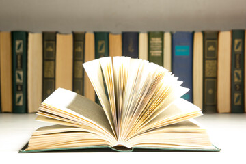 Wall Mural - Composition with vintage old hardback books, diary, fanned pages on wooden deck table and red background. Books stacking. Back to school. Copy Space. Education background.