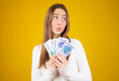 © Danko - Young beautiful caucasian girl holding money over yellow background