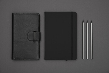 Black leather cover notebook flat lay over grey