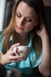 © shymar27 - Young beautiful girl with brown hair drinks coffee in a cafe.