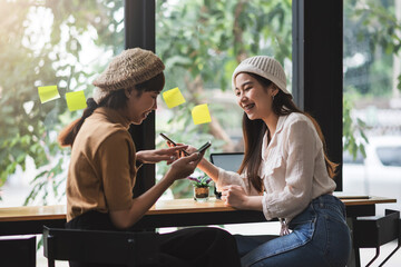 Free time of two Asian woman Who are happy to chat at the coffee shop