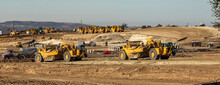 Earth Moving Equipment At A Construction Grading Site With Other Tractors Lined Up In The Background