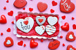 Round gingerbread love, with hearts lies in a box on a red substrate for delivery to people from the restaurant on valentine's day. Cookies in a box in the form of baked hearts.