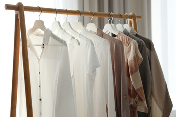 Different stylish clothes on rack in room