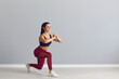 © Studio Romantic - Smiling fitness trainer showing how to do fitness exercise. Happy fit young woman in sports bra and leggings doing forward lunges holding hands together in front of chest during workout at the gym