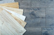 Vinyl and linoleum samples on a wooden background. Vinyl for flooring with wood grain texture and pattern.