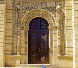 Wall Mural - Azerbaijan, beautiful decorated entrance door of the Juma Mosque in Baku. A pair of shoes are outside.