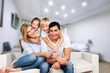 © BillionPhotos.com - Beautiful smiling lovely family sitting on sofa