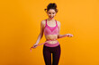 © Look! - Photo of girl on diet. Brunette woman in pink sportswear posing in studio.