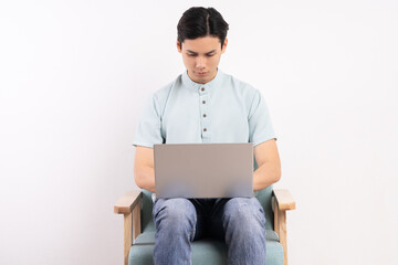 Wall Mural - Handsome man with laptop sitting on the working sofa