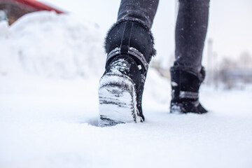 A person is walking on a slippery road, the first snow in the park