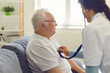 © Studio Romantic - Doctor listening to the heart and breathing of an older man through a stethoscope on his chest.