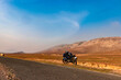 © explorewithinfo - countryside empty rural road with motorcycle parked and surrounded by mountains at morning