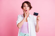 © deagreez - Photo of amazed funny young woman dressed white shirt holding credit card hand arm cheek isolated pink color background