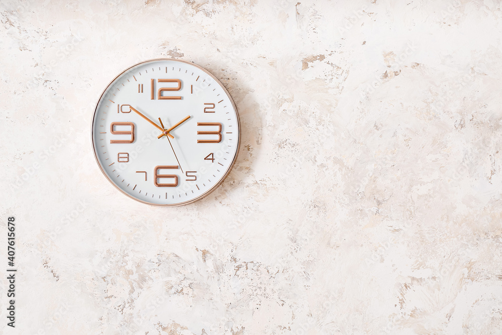 Modern clock hanging on light wall