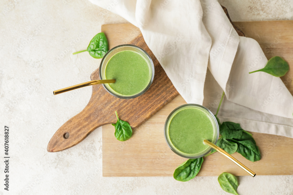 Glasses of healthy spinach smoothie on light table