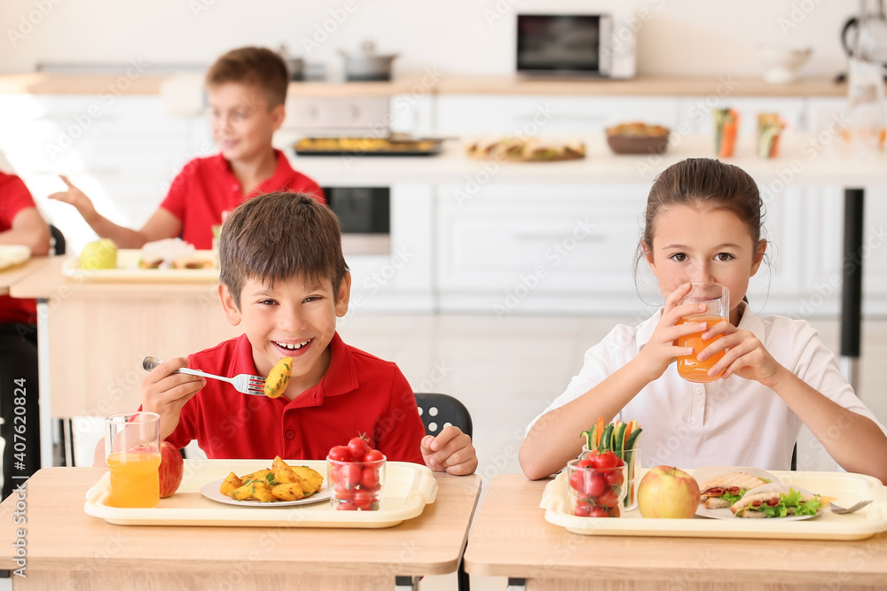 Pupils having healthy lunch in classroom