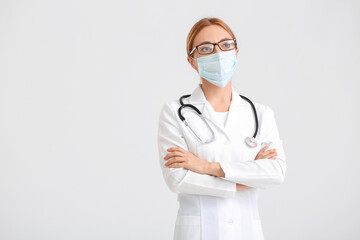 Poster - Portrait of female doctor wearing medical mask on light background