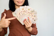 successful Asian woman hand showing Thai money banknotes ,investment and earning concept
