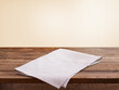 Empty wooden deck table with tablecloth over wall background