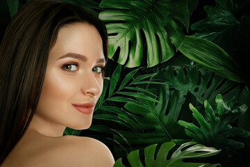 Wall Mural - Beautiful young woman and tropical leaves, closeup view with space for text. Spa portrait