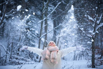 Wall Mural - Enjoying winter time woman playing with snow