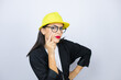 © Irene - Young architect woman wearing hardhat Pointing to the eye watching you gesture, suspicious expression