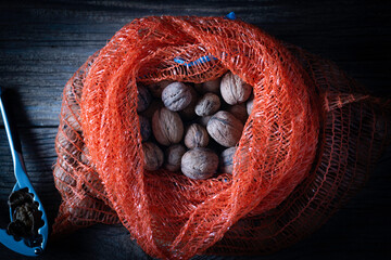 Walnuts in a bag on a wooden background