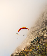 Paragliders flying down the mountain landscape during warm sunrise, what an adventure