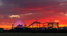 Beautiful And Colorful Sunset At Santa Monica, With The Pacific Park Amusement Park Silhouetted  In The Foreground..