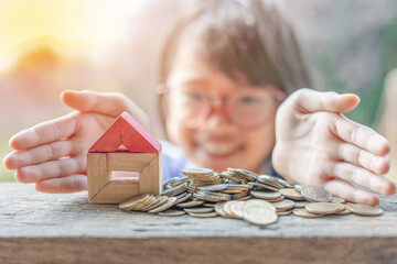 Wall Mural - Hand protecting stacked coins and wooden house .Property investment and house mortgage financial concept,