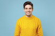 © ViDi Studio - Young caucasian good-looking attractive cheerful friendly student man 20s in casual knitted cozy yellow fashionable sweater looking camera with smile isolated on blue color background studio portrait