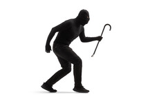 Full Length Shot Of A Burglar In Black Clothes With A Balaclava And A Crowbar Walking Slowly