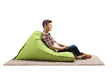 Poster - Profile shot of a guy sitting on a green bean bag armchair