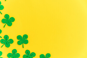 St Patricks Day background. Simply minimal design with green shamrock. Clover leaves isolated on yellow background. Symbol of Ireland. Lucky fortune wish concept. Flat lay top view layout copy space.