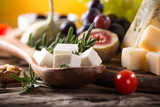 Fototapeta Miasto - Set of different types of cheese on old wooden background, close up.