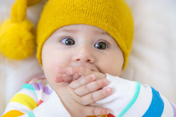 Poster - Baby puts his hands in his mouth. Selective focus.