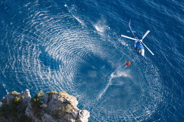Fire fighter helicopter collect water over the sea