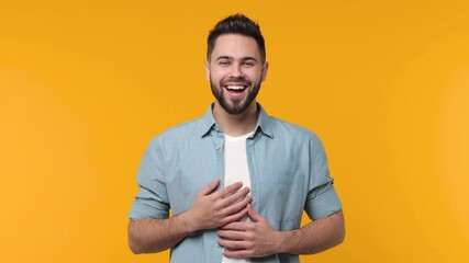 Wall Mural - Surprised excited bearded young man 20s in casual blue shirt white t-shirt isolated on yellow background in studio. People sincere emotions lifestyle concept. Say wow covering mouth put hands on head