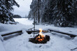 Bright bonfire in a winter forest. Beautiful snow covered trees. Kettle on fire. Camping, hiking concept. Finland.