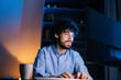 © dikushin - Close-up face of happy smiling bearded young man looking intently at computer monitor screen while working on at late night. Concept of remote working, distance learning, Concept of remote working.