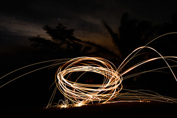 Wall Mural - light painting with steel wool - pyrotechnic display at night