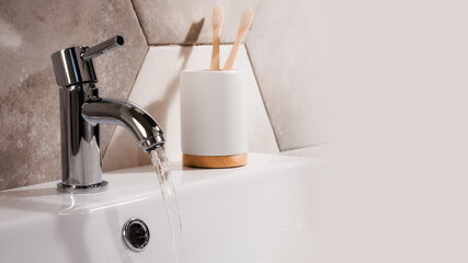 Canvas Print - Closeup shot of water flowing from a basin mixer tap in the bathroom