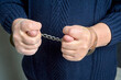 © Евгений Порохин - men's hands in handcuffs show a fig