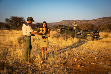 Wall Mural - Guide shows something to brunette near jeep