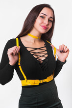 A Young Girl, Of European Appearance With A Beautiful Figure Demonstrates A Leather Accessory On Herself. Bright Leather Garment Detail. Stylish Belts On Clothes. Leather .harness