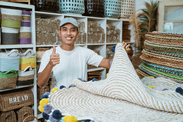 man with thumbs up holding knit carpet craft among craft items in craft gallery