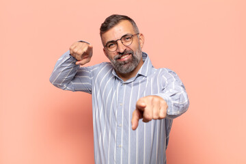 adult handsome man feeling happy and confident, pointing to camera with both hands and laughing, choosing you